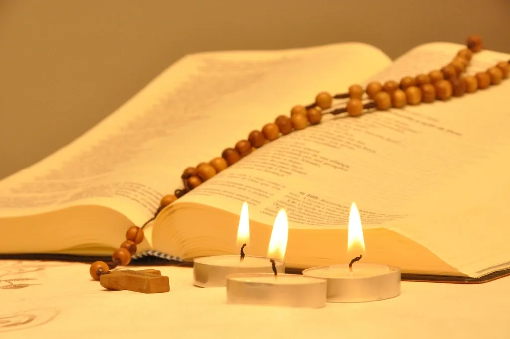 Rosario y velas sobre las escrituras